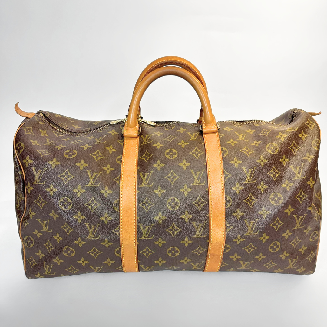 Brown travel bag with tan leather handles on a light gray background