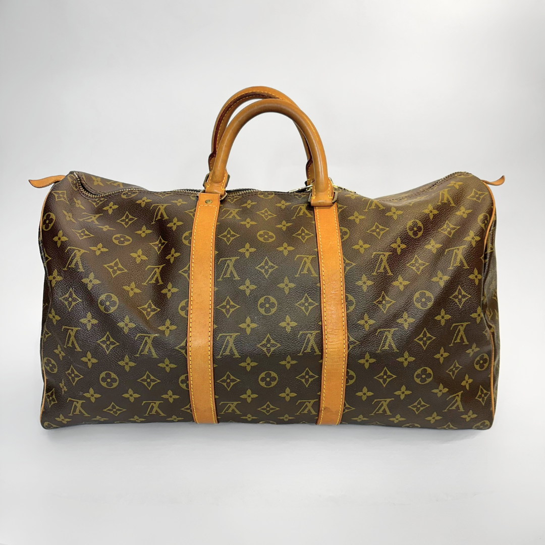 Brown travel bag with tan leather straps on a white background