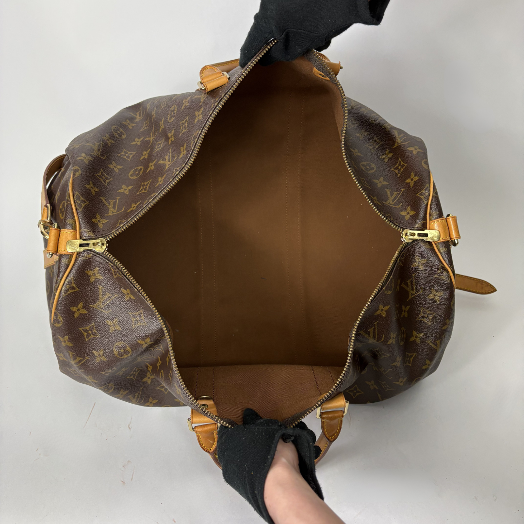 Brown leather duffel bag with tan straps on a white background