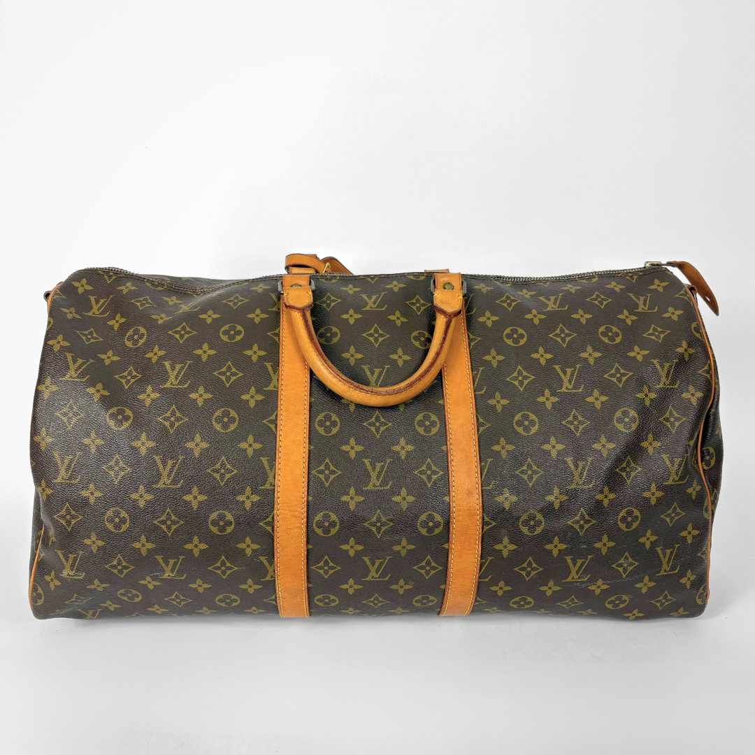 Louis Vuitton monogram travel bag with brown handles on a white background