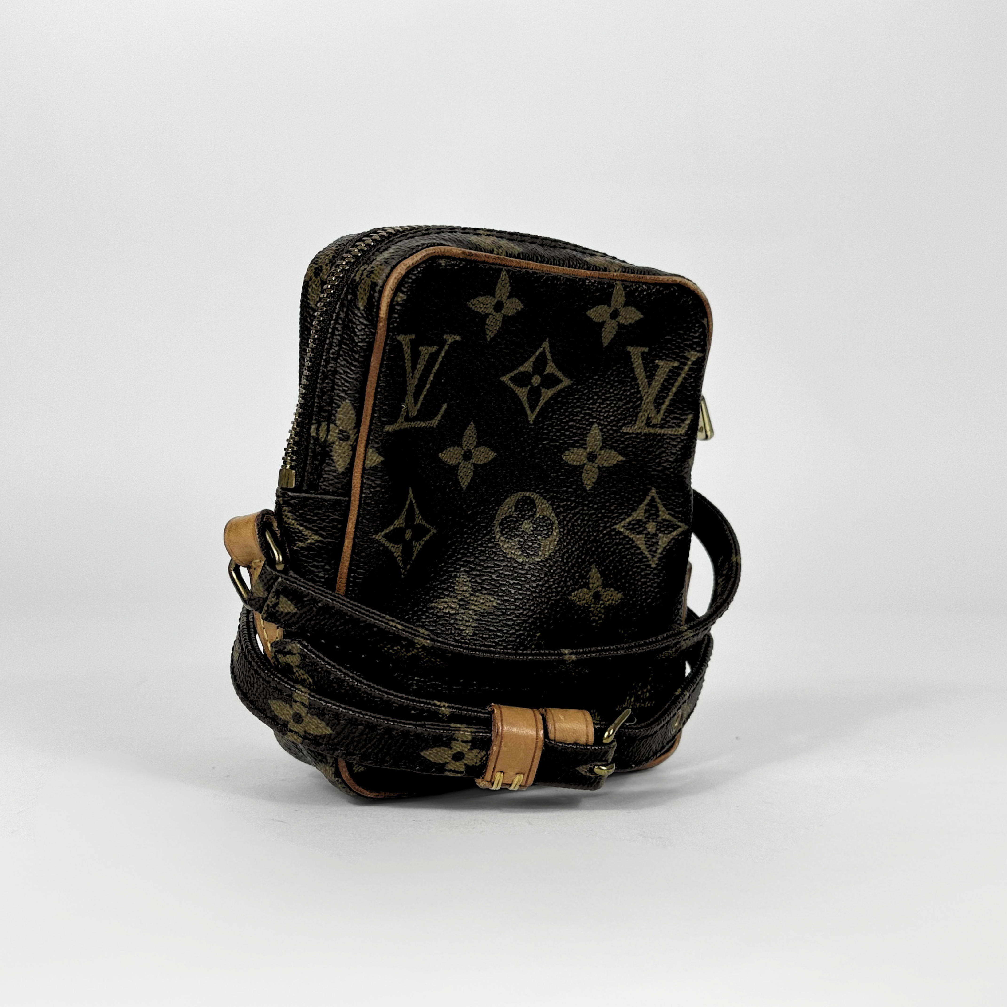 Black leather bag with brown monogram pattern on a white background